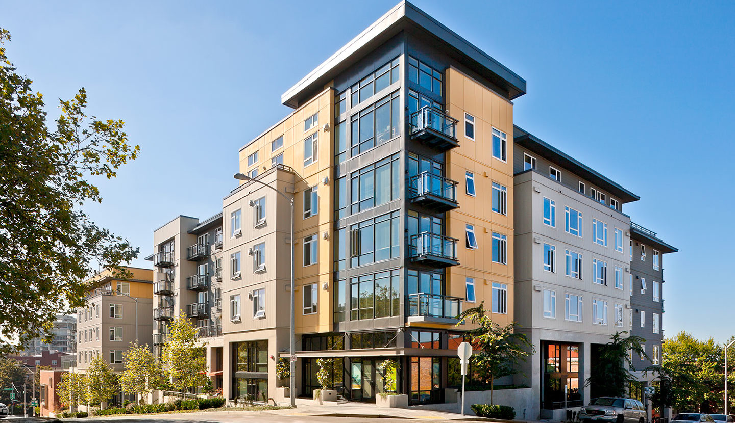 Corner view of the entrance of a four story apartment complex