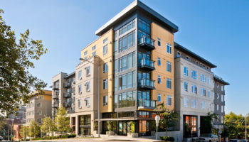 Corner view of the entrance of a four story apartment complex