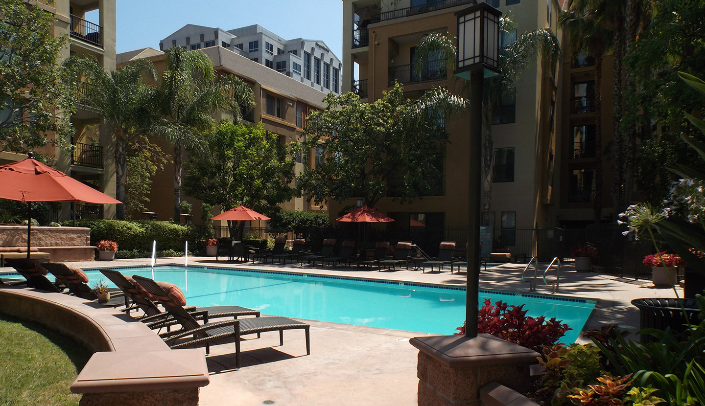 Community pool area with trees and seating