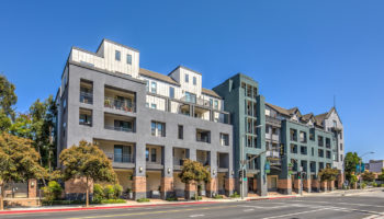 Street view of a modern apartment building with terraces