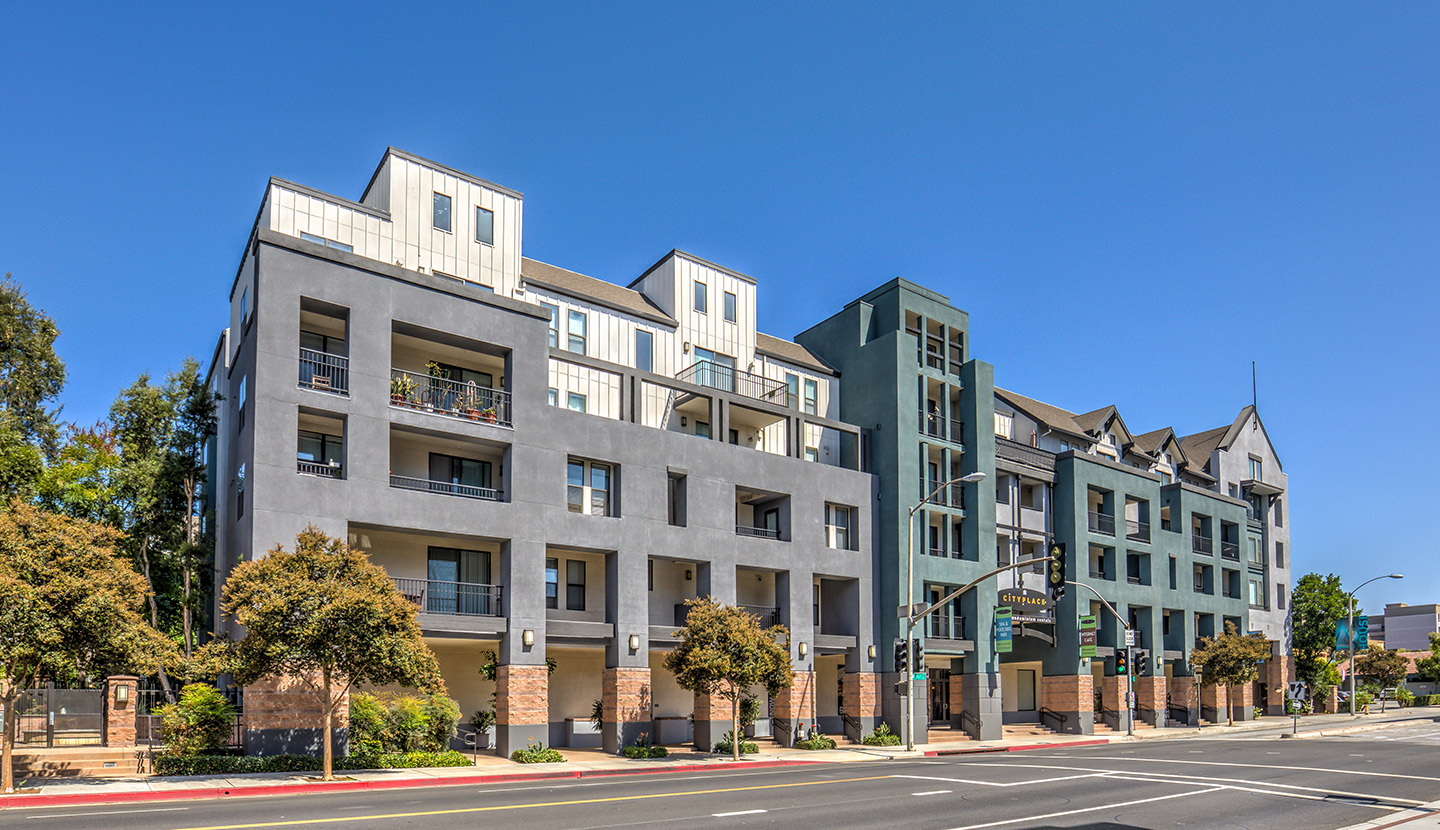 Street view of a modern apartment building with terraces