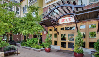 Front door of the apartment complex with a dexter sign