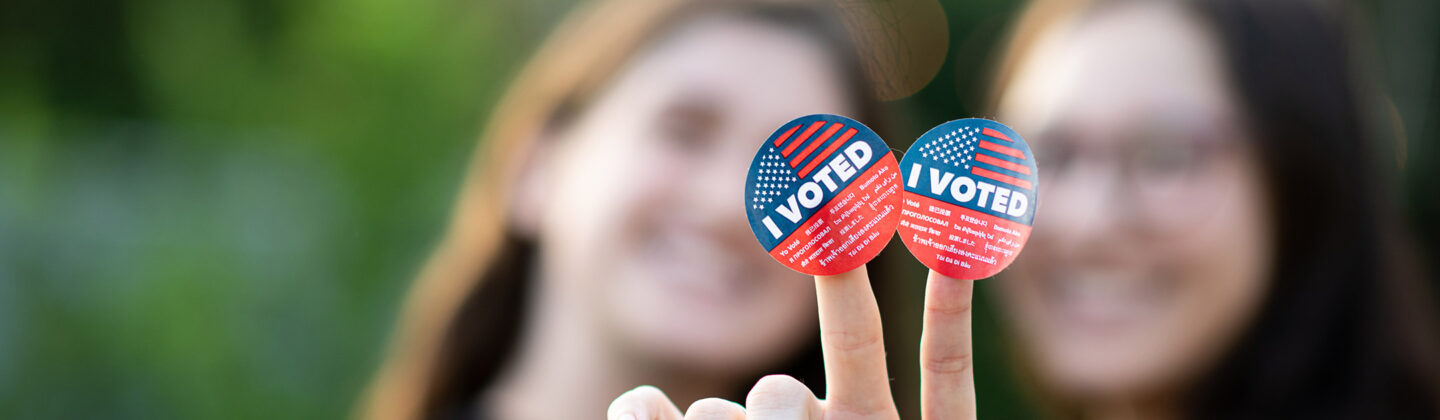 two women holding I voted stickers